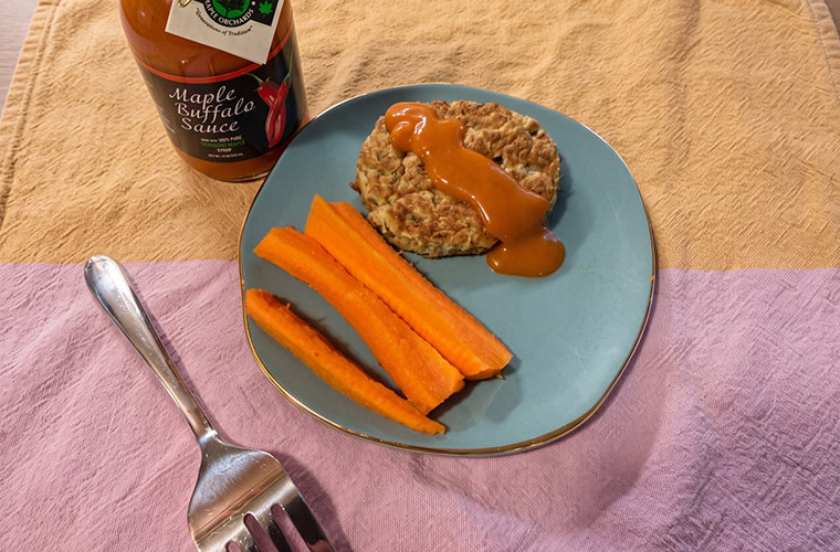 Photo of Zucchini Pancakes on a plate with carrots and Maple Buffalo Sauce